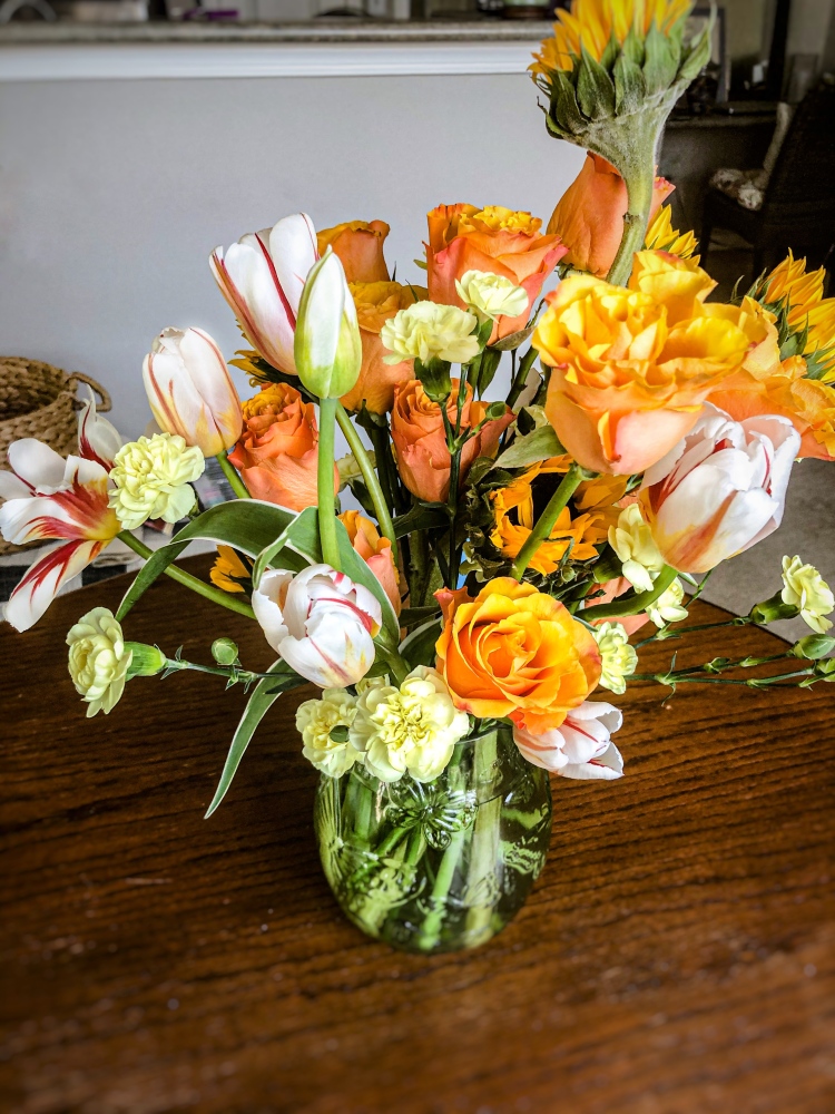 Warm floral arrangement, sunflower, tulips, orange roses, flower centerpiece