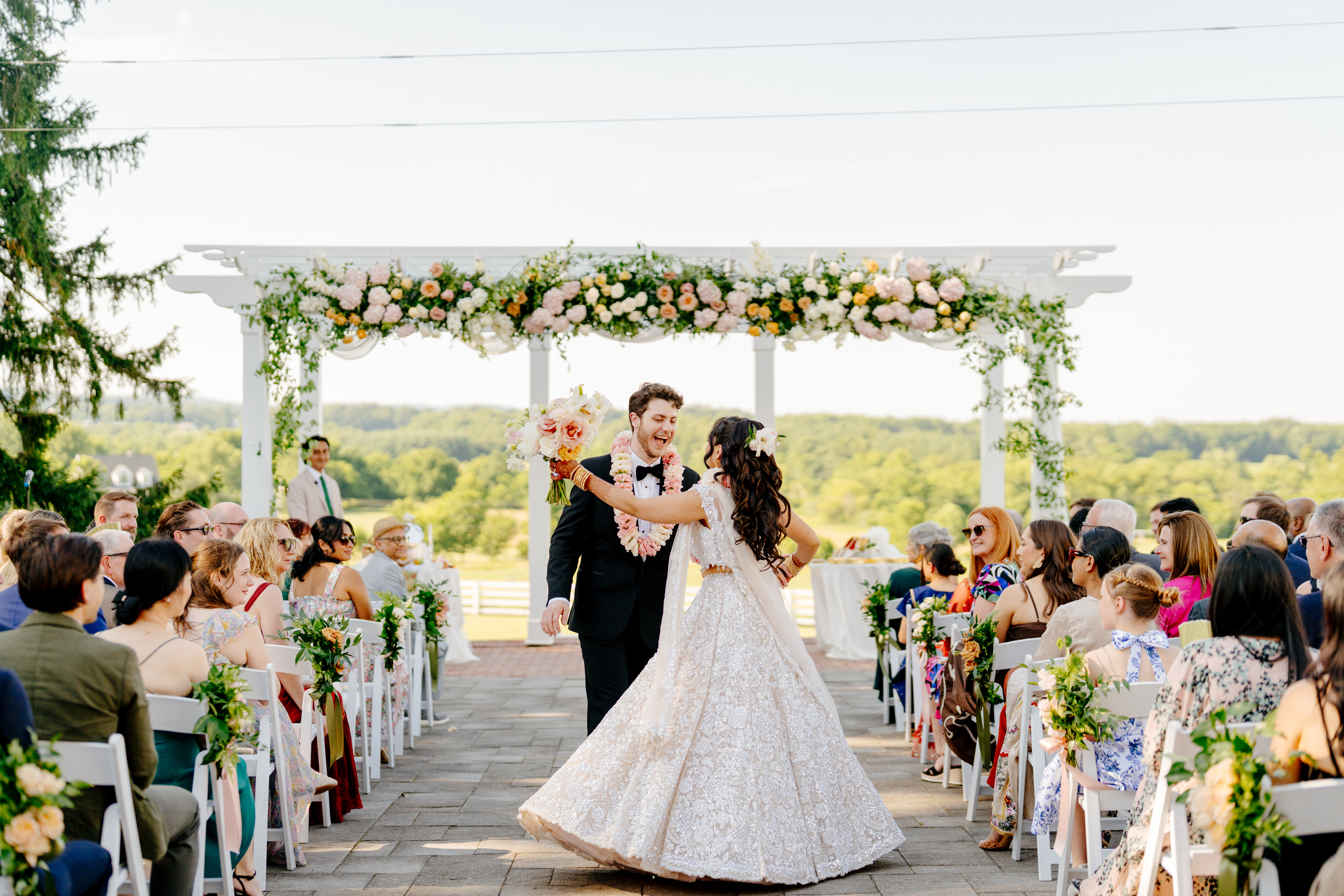Garden-style wedding ceremony arch with roses and hydrangea in soft spring colors